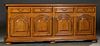 French Provincial Carved Oak Sideboard, early 20th c., the stepped rounded edge and corner top over four frieze drawers above four fielded panel cupbo
