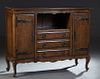 French Louis XV Style Carved Oak Sideboard, early 20th c., the stepped rounded corner top over central open storage above a bank of three drawers flan