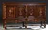 Spanish Renaissance Style Carved Oak Sideboard, 20th c., the stepped crown over four doors carved with game birds and an agrarian couple, flanked by f