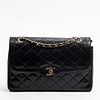 Chanel Paris Double Flap Shoulder Bag, c. 1989, in black quilted lambskin leather with golden and silvered hardware, the interior of the bag lined in 