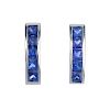 A pair of sapphire ear studs. Each designed as a calibre-cut sapphire line, within a channel setting