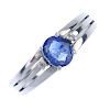 A sapphire and diamond three-stone ring. The oval-shape sapphire, with brilliant-cut diamond sides,