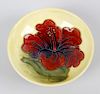 A small Walter Moorcroft dish. Of shallow form having central orchid flower upon a merging pale yell