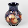 A Moorcroft pottery 'Finches' pattern vase. The bulbous body with tube-lined decoration on a blue gl