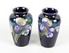 A small pair of Moorcroft orchid vases. The ovoid bodies having blue glazed ground decorated with or