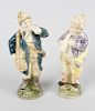 A pair of glazed pottery figures. Each modelled as a male musician carrying a guitar or trumpet and