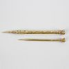 A yellow metal retractable pencil, the hexagonal barrel having foliate engraved decoration and vacan