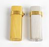 A pair of lighters by Christian Dior. Comprising a gold plated example, and another base metal, both