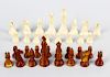 A stained ivory chess set. Comprising natural and brown stained sectional pieces, the kings of typic