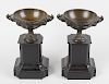 A pair of bronze pedestal urns. Each of shallow form with twin phoenix handles, the exterior decorat