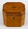 A George III inlaid satinwood tea caddy, of hinged canted oblong cover centred by a bat's wing pater