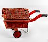 A 1930s GPO type toy cart. With red painted hinged cane and wicker roof, over conforming body and wo