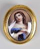 A 19th century oval portrait miniature brooch, female depicted half length with hands to chest and w