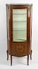 A 20th century French bow front vitrine or display cabinet Having a pierced gilt metal gallery over