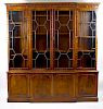 A mahogany reproduction breakfront bookcase cabinet The upper section with dentil cornice and trefoi