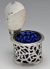 An early Victorian silver mustard pot with blue glass liner, the circular form with foliate scroll o