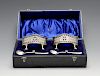 A cased pair of Edwardian silver open salts, the oval pierced bodies with beaded border, blue glass