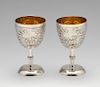 A pair of small Chinese export goblets, each decorated in relief with flowers and leafy stems agains