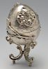 A late nineteenth century Eastern European egg ornament on stand, applied decoration of twin opposed