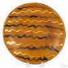 Pennsylvania redware plate, 19th c., with alternating cream and black squiggle lines, 10'' dia.