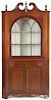 Pennsylvania pine two-part corner cupboard, ca. 1830, retaining a red stain surface, 84'' h.,