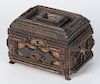 Tramp art carved alms box, 19th/20th c., with applied metal lion mask handles and feet