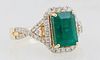 Lady's 18K Yellow Gold Dinner Ring, with a 3.05 ct. emerald atop an octagonal border of small round diamonds, the pierced lugs and shoulders of the ba
