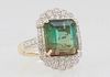 Lady's 14K Yellow Gold Dinner Ring, with an 8.02 carat square green tourmaline atop a scalloped oval floriform top mounted with round diamonds, the sh