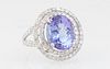 Lady's 14K White Gold Dinner Ring, with an oval 6.72 ct. tanzanite atop a border of round diamonds and a pierced outer border of round diamonds, the s