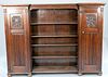 Large carved oak bookcase having carved doors on each side and four shelves in the center. ht. 69 in.; wd. 95 in.; dp. 14 in.