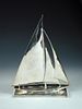 A 20th century electroplate model of a yacht, the base with simulted waves, 31 x 23cm (12 x 9in) <br