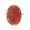A coral cameo brooch. The oval-shape brooch carved to depict a portrait of a young man in classical