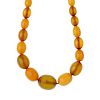 A natural amber bead necklace. Comprising thirty-four graduated oval-shape beads measuring 2 to 0.8c