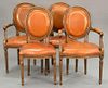 Set of four French style chairs with leather seats and backs including two armchairs and two side chairs.
