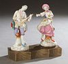 Pair of German Musical Porcelain Figurines, c. 1900, of a male musician and a female dancer, on a serpentine pierced brass base. She rotates to wind t