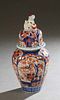 Japanese Imari Porcelain Covered Jar, late 19th c., the lid with a Foo dog handle, over ribbed sides with floral and bird decoration in the typical pa