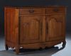 French Provincial Louis XV Style Carved Cherry Sideboard, 19th c., the canted corner two board top over two frieze drawers above double cupboard doors
