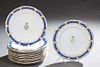 Set of Twelve Continental Porcelain Dinner Plates, 19th c., with scalloped gilt decorated edges around blue banding, and a painted armorial center, H.