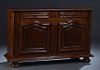 French Louis XIII Style Carved Oak Sideboard, 19th c., the stepped rounded corner top over two frieze drawers flanking an applied scroll carved pilast