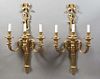 Pair of Louis XVI Style Gilt Bronze Three Light Wall Sconces, 20th c., with a bow and ribbon garland surmounted torch form back plate, issuing three s