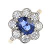 A sapphire and diamond cluster ring. The oval-shape sapphire, within a brilliant-cut diamond surroun
