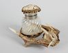 An early 20th century glass inkwell of writhen twist form, the hinged stag horn cover with carved de