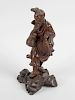 An oriental carved hardwood study of a fisherman, standing and holding a basket and his catch, upon