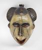 An African tribal carved softwood maskPossibly Punu, GabonModelled with top-knot and unusual hatch-c