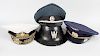 A box containing a Soviet naval uniform with peaked cap, a similar military uniform with peaked cap,
