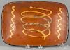 New England redware loaf dish, 19th c., with yellow slip decoration, 8'' h., 11 3/4'' w.