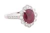 Lady's Platinum Dinner Ring, with a 2.57 ct. oval ruby atop a floriform border of round diamonds, the shoulders of the band also mounted with small ro