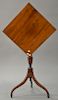 Federal mahogany candlestand having square tip top on urn carved shaft on tripod base, circa 1800. 
ht. 30 in.; top: 17 3/4" x 18 1/4"