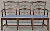 Custom mahogany triple chair back settee, Chippendale style with ladder backs and slip leather upholstered seat set on square tapere...