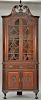 Custom mahogany corner china cabinet in two parts, upper portion with large finial and broken arch top over deep shell over two shap...